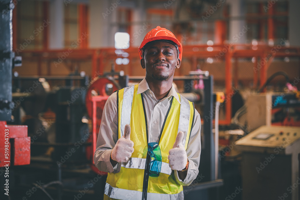Portrait African American Black afro worker in factory, Cameroon Black man employee work in production plant manufacture factory industry and operator line machine steel metal using helmet for safety Portrait African American Black afro worker in factory, Cameroon Black man employee work in production plant manufacture factory industry and operator line machine steel metal using helmet for safety