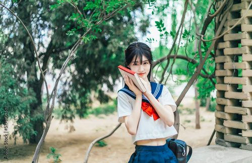 A girl in a Japanese school uniform at an amusement park photo