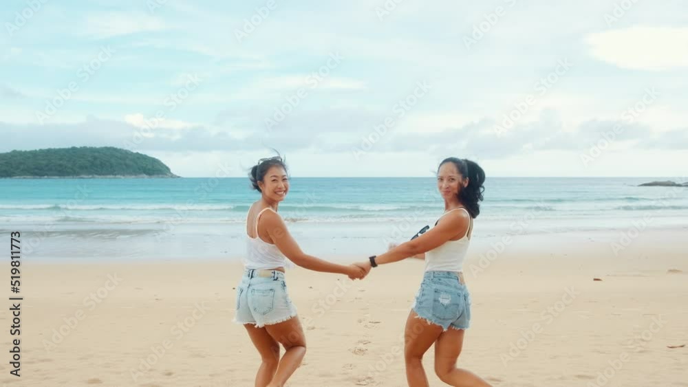Two attractive women friends enjoying and relaxing on the beach, Summer, vacation, holidays, Lifestyles concept Two attractive women friends enjoying and relaxing on the beach, Summer, vacation, holidays, Lifestyles concept