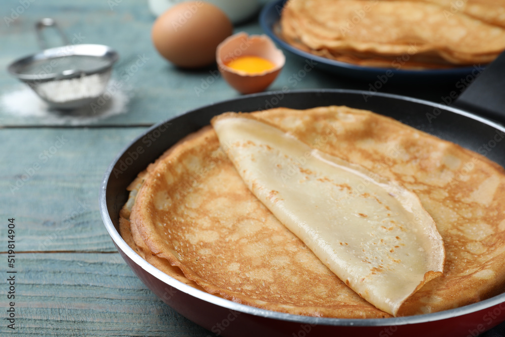 Delicious thin pancakes on blue wooden table, closeup Delicious thin pancakes on blue wooden table, closeup