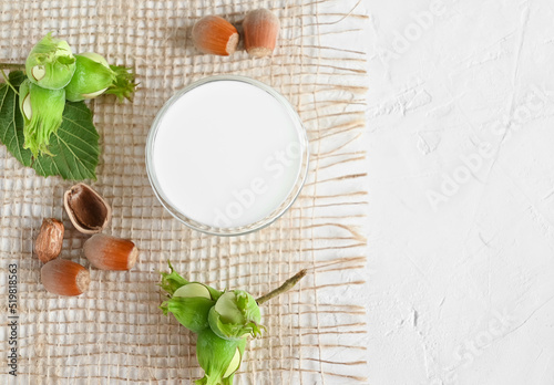 Hazelnut non dairy milk and hazelnuts top view. This milk is an excellent source of antioxidants, phytosterols and heart-healthy fats and supports and improves the elasticity of vascular walls
