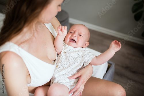Newborn crying boy. the child is tired and hungry in the arms of the mother. children are crying. infant cry.
