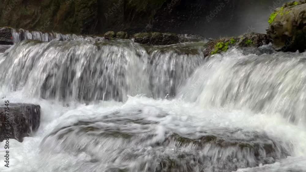 Close-up side view of cascading waterfall rapidly flowing down the rocks in the rainforest. Sumampan Waterfall in Ubud in Bali, Indonesia. 4K Video. Close-up side view of cascading waterfall rapidly flowing down the rocks in the rainforest. Sumampan Waterfall in Ubud in Bali, Indonesia. 4K Video.
