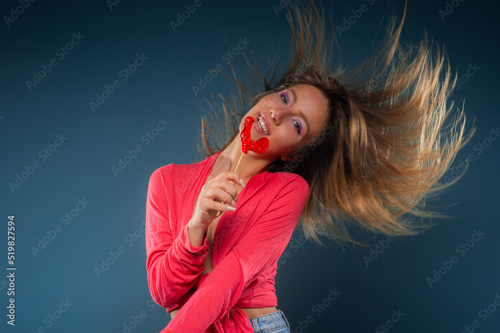 Having fun with the lolipop while flipping her hair Having fun with the lolipop while flipping her hair