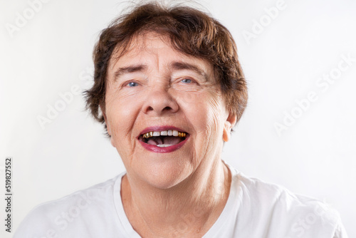 Portrait of a happy senior woman pensioner laughing and looking at the camera. White background. The concept of retirement, Alzheimer's and psychology