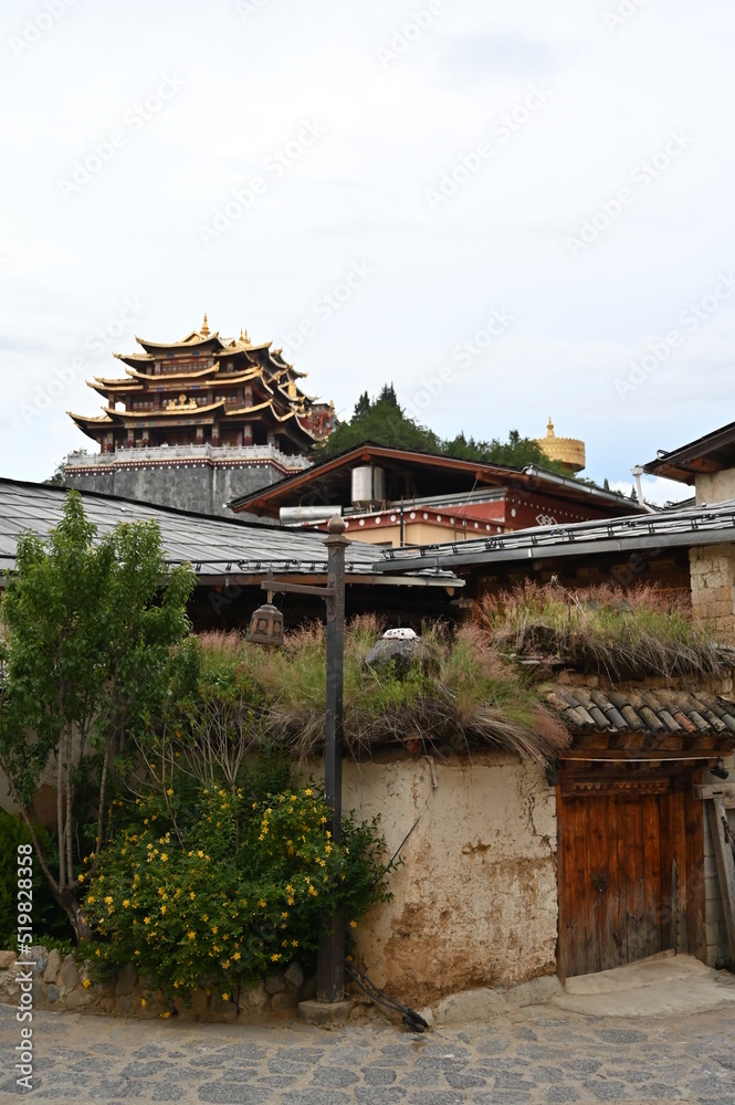 Exploring the old town in Shangri-La - with a great mixture of old and restored ethnic architecture buildings and temple in the distance Exploring the old town in Shangri-La - with a great mixture of old and restored ethnic architecture buildings and temple in the distance