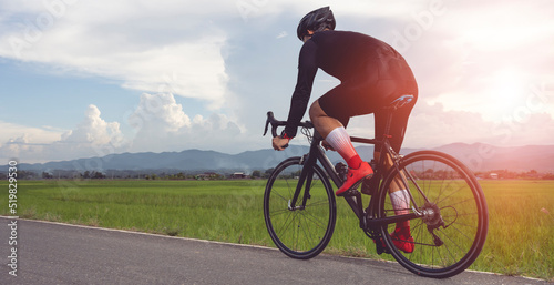 Fototapeta Naklejka Na Ścianę i Meble -  Professional cyclist in cycling training suit against green nature blur background Healthy fitness and lifestyle concepts.