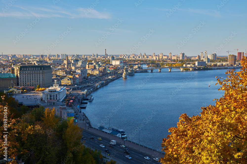 View from the Glass Bridge to the city center, road, cars. Public transport. View of the Dnieper river with rocks, green hills and boats. Kyiv. Urban city life.
