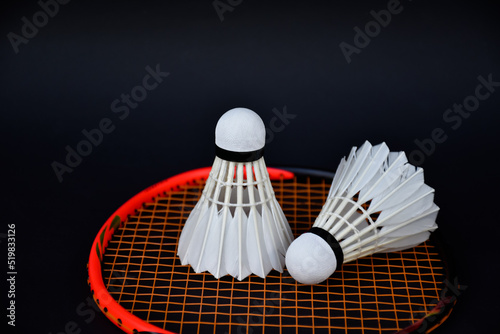 White cream badminton shuttlecock and badminton rackets on dark floor of indoor badminton court, soft and selective focus, concept for badminton sport lovers around the world © Sophon_Nawit