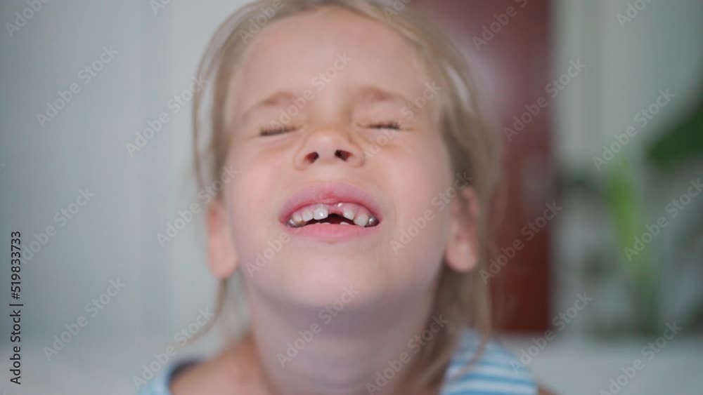 Happy child smiles with his teeth at camera. Cute little girl in bright room alone with beautiful toothless smile. child is losing her milk teeth. Happy child smile at the camera. Happy child smiles with his teeth at camera. Cute little girl in bright room alone with beautiful toothless smile. child is losing her milk teeth. Happy child smile at the camera.