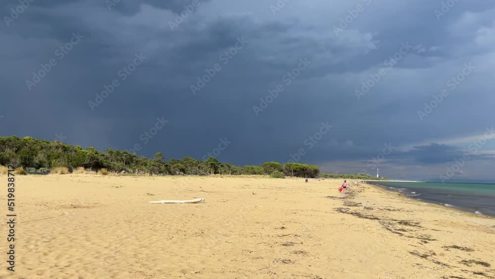 Beautiful empty sand beach with incoming storm in the background. Extreme weather caused by climate changes. Hot summer in Italy, dog beach in Bibione. Beautiful empty sand beach with incoming storm in the background. Extreme weather caused by climate changes. Hot summer in Italy, dog beach in Bibione.
