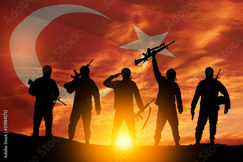 Silhouettes of soldiers on a background of Turkey flag and the sunset or the sunrise.