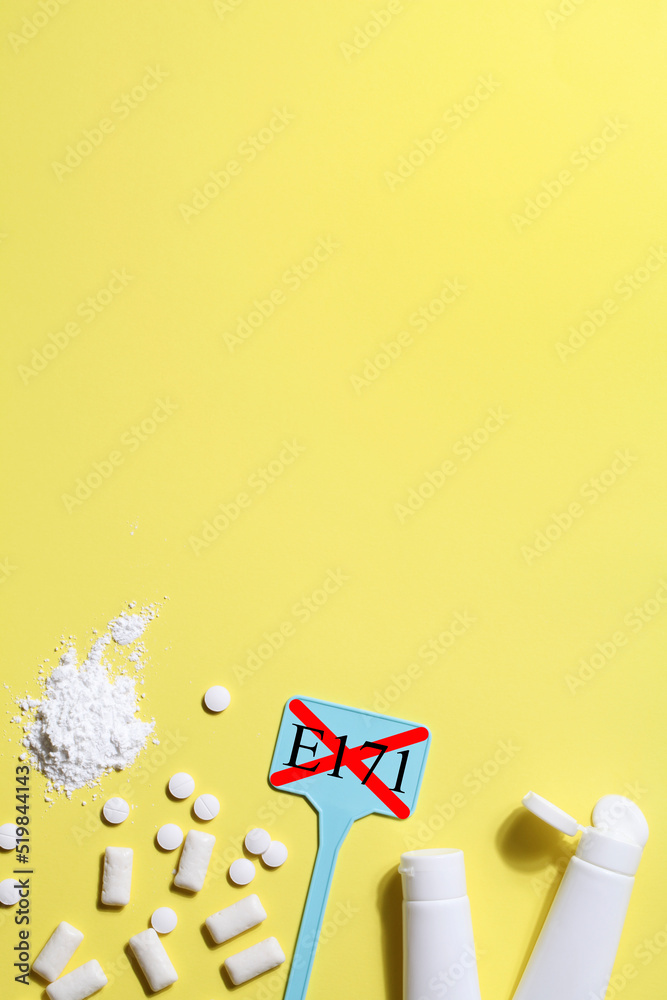 Titanium dioxide, E171, dangerous additive concept. gum, pills, toothpaste, powder and sign with E171 on yellow background. copy space