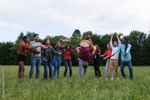 Group of young people cheering to do a flip in the park outdoors