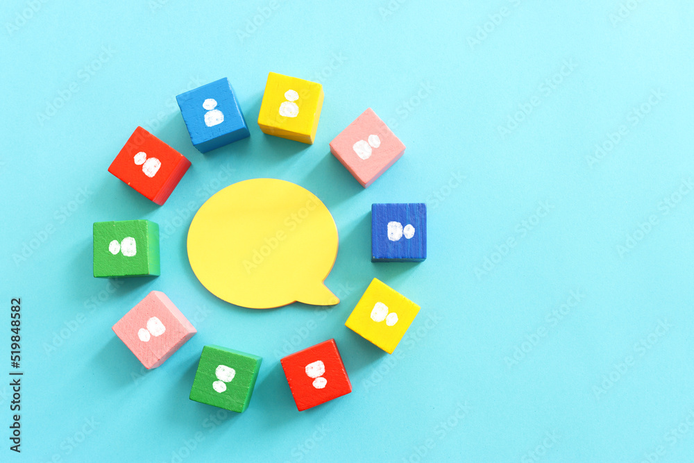 Top view image of circle of wooden cubes and people icons. Concept of society and connection and communication