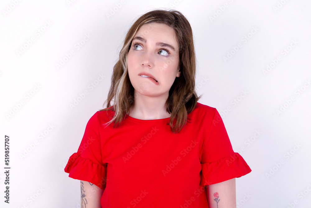 young caucasian woman wearing red T-shirt over white background making grimace and crazy face, screaming out of control, funny lunatic expressing freedom and wild. young caucasian woman wearing red T-shirt over white background making grimace and crazy face, screaming out of control, funny lunatic expressing freedom and wild.