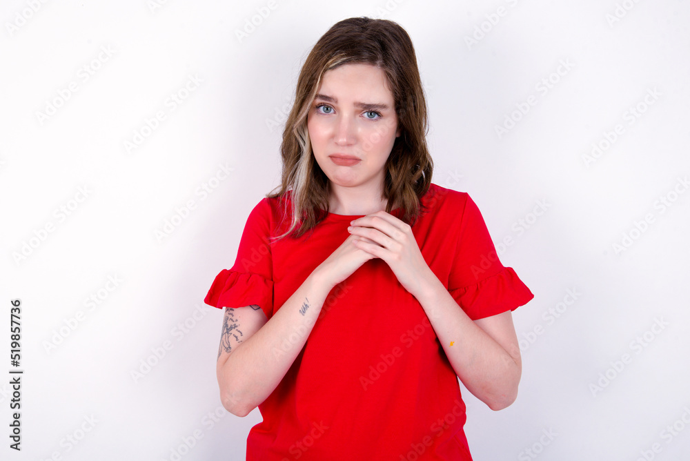 Sad young caucasian woman wearing red T-shirt over white background desperate and depressed with tears on her eyes suffering pain and depression in sadness facial expression and emotion concept Sad young caucasian woman wearing red T-shirt over white background desperate and depressed with tears on her eyes suffering pain and depression in sadness facial expression and emotion concept