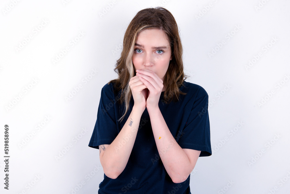 young caucasian woman wearing black T-shirt over white background holding oneself, feels very cold outside, hopes that will not get cold young caucasian woman wearing black T-shirt over white background holding oneself, feels very cold outside, hopes that will not get cold
