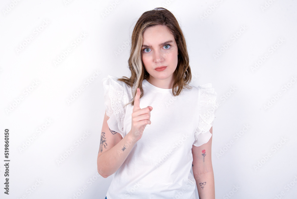 young caucasian woman wearing white T-shirt over white background frustrated and pointing to the front young caucasian woman wearing white T-shirt over white background frustrated and pointing to the front