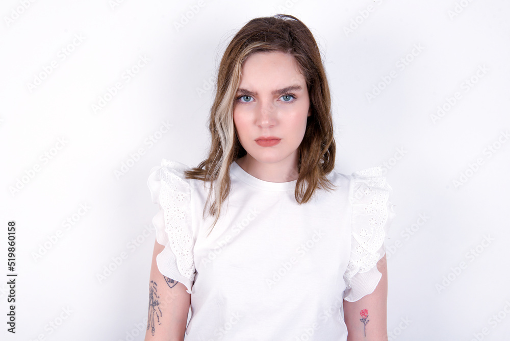 young caucasian woman wearing white T-shirt over white background Pointing down with fingers showing advertisement, surprised face and open mouth young caucasian woman wearing white T-shirt over white background Pointing down with fingers showing advertisement, surprised face and open mouth