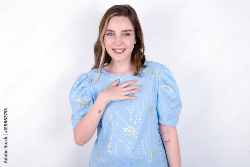 young caucasian woman wearing blue T-shirt over white background smiles toothily cannot believe eyes expresses good emotions and surprisement young caucasian woman wearing blue T-shirt over white background smiles toothily cannot believe eyes expresses good emotions and surprisement