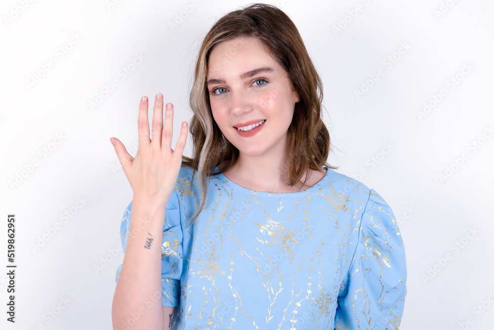 young caucasian woman wearing blue T-shirt over white background smiling and looking friendly, showing number five or fifth with hand forward, counting down young caucasian woman wearing blue T-shirt over white background smiling and looking friendly, showing number five or fifth with hand forward, counting down