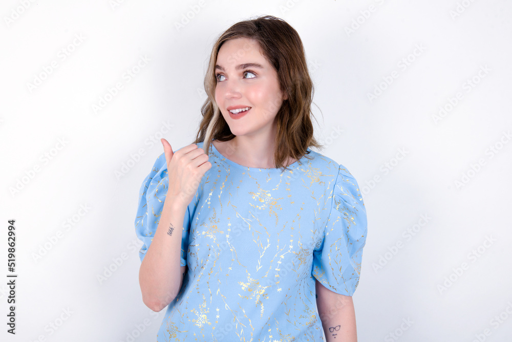 young caucasian woman wearing blue T-shirt over white background points away and gives advice demonstrates advertisement young caucasian woman wearing blue T-shirt over white background points away and gives advice demonstrates advertisement