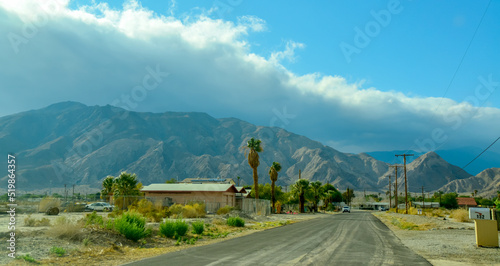 CALIFORNIA, USA - NOVEMBER 27, 2019: country road with a palm tree near the house against the backdrop of the mountains in California