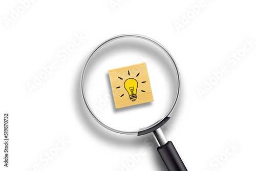 Creative idea concept, magnifying glass and light bulb icon on wooden block with white background