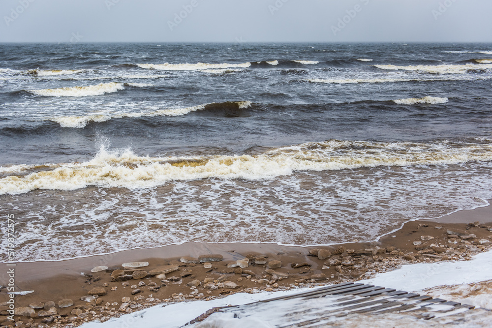 Winter Baltic Sea beach is snowy and there are big waves in the sea Winter Baltic Sea beach is snowy and there are big waves in the sea