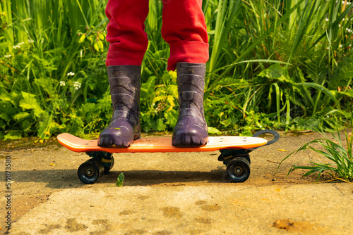 A child rides a skateboard in dirty shoes