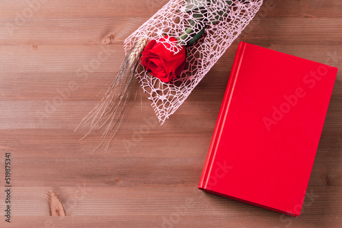 Red rose and red book on pink background, Sant Jordi holiday card photo