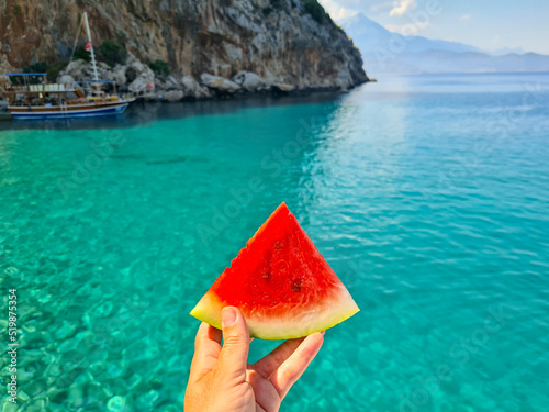 Photography Bright red watermelon on blue sea background.