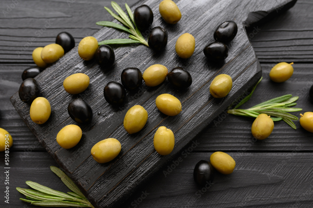 Black and green olives on a dark wooden black background. Black and green olives on a dark wooden black background.