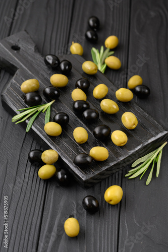 Fototapeta Naklejka Na Ścianę i Meble -  Black and green olives on a dark wooden black background.