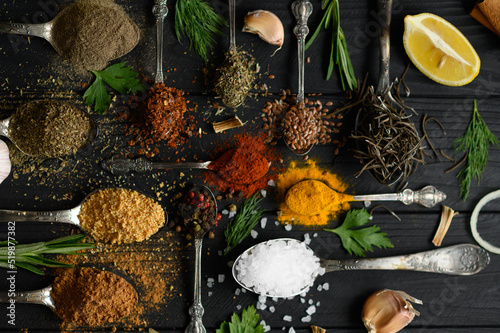 Colorful various herbs and spices for cooking on dark wooden rustic background