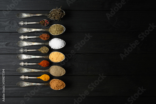 Colorful various herbs and spices for cooking on dark wooden rustic background