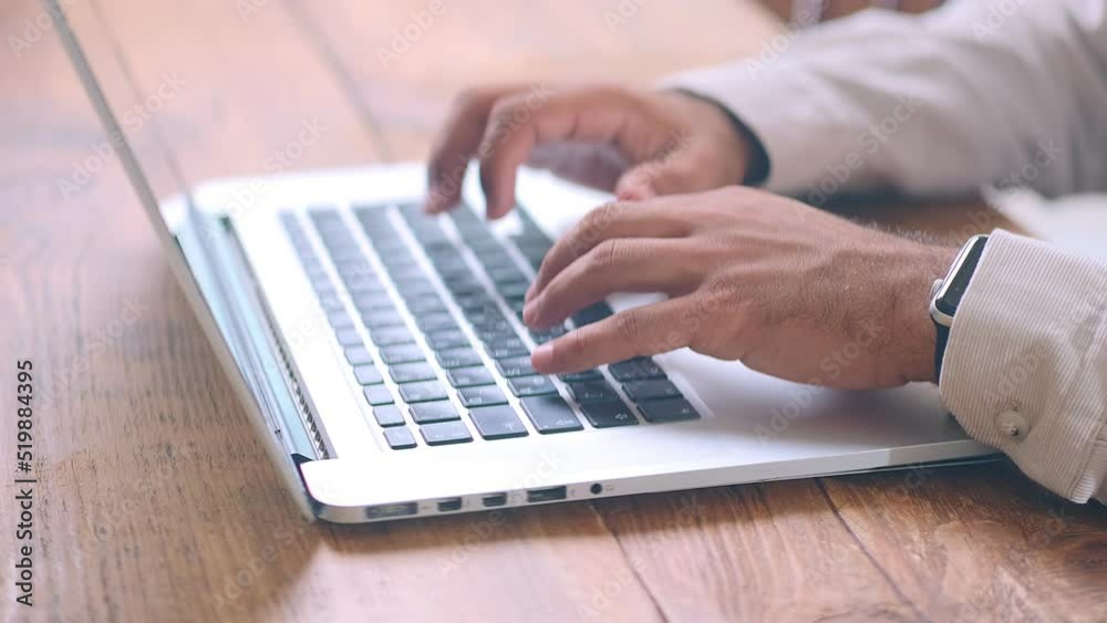 Man hands typing on keyboard of silver laptop performing work of office employee or secretary filling out online forms or writing business letter for partners and company staff . Close-up Man hands typing on keyboard of silver laptop performing work of office employee or secretary filling out online forms or writing business letter for partners and company staff . Close-up