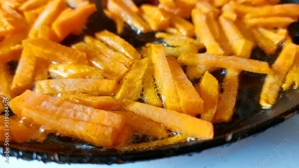 Orange carrots are cut into blocks. Frying in a frying pan with vegetable oil. Orange carrots are cut into blocks. Frying in a frying pan with vegetable oil.
