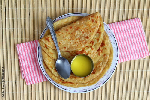 indian gujarati traditional sweet stuffed flatbread or sweet roti vedmi also known in india as holige,puran poli served with pure cows ghee clarified butter and papad photo