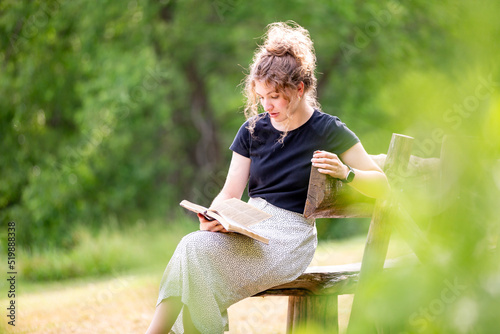 Woman sitting alone reading Bible