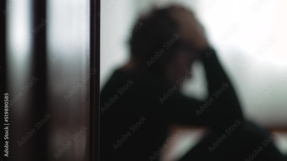 Blurry shot of person in crisis sitting on floor. Out of focus take of young woman during hard times Blurry shot of person in crisis sitting on floor. Out of focus take of young woman during hard times