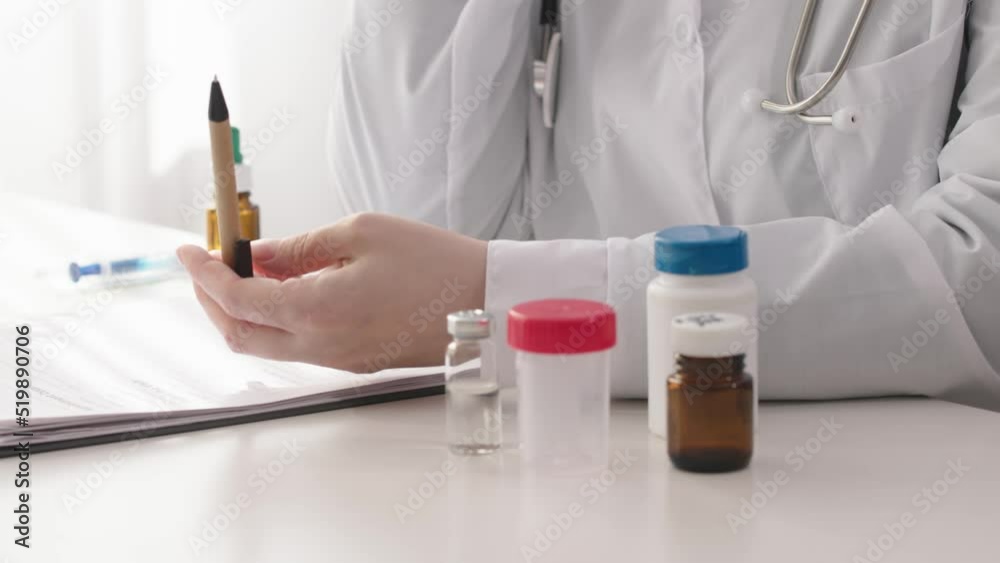 doctor talking phone, holding pen in hands gesturing while phone call in cabinet clinic office. stethoscope, white coat uniform, medicine bottles on white table, papers. doctor giving recommendations doctor talking phone, holding pen in hands gesturing while phone call in cabinet clinic office. stethoscope, white coat uniform, medicine bottles on white table, papers. doctor giving recommendations