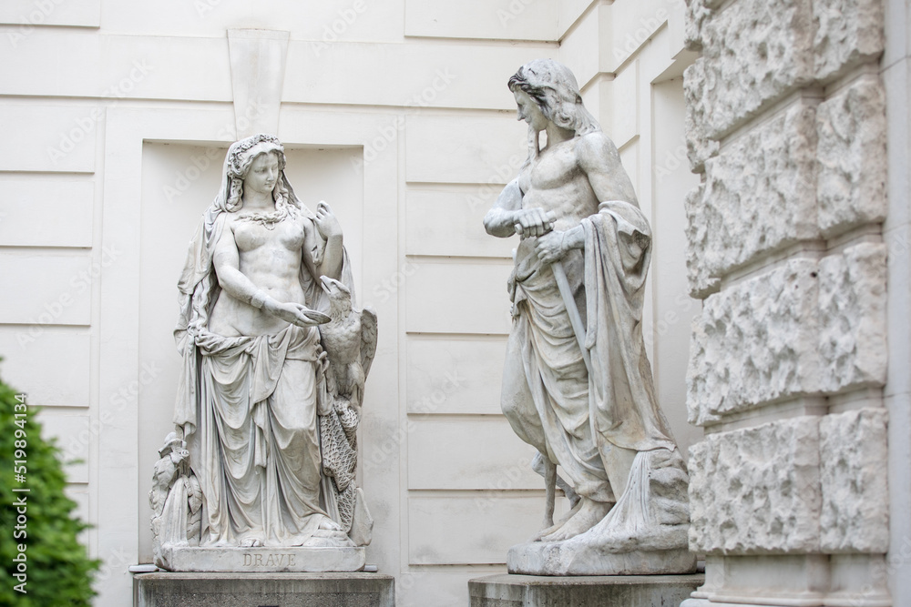 Statue of Drave and Inn in Austria, marble statues in the castle park near white wall