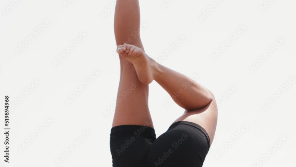 Young blonde woman doing gymnastics handstand on the coasters Young blonde woman doing gymnastics handstand on the coasters