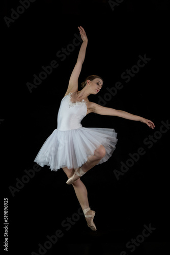 Ballet dancer on a black background. The dancer in a dance. Ballet pose