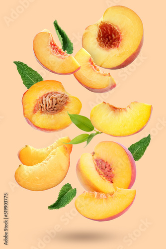 Flying cut ripe peaches on beige background