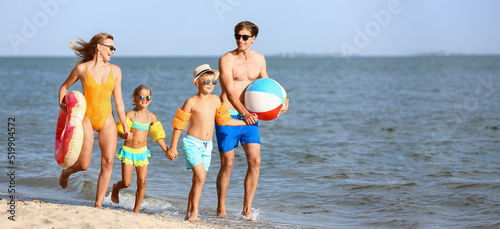 Walking family on sea beach at resort