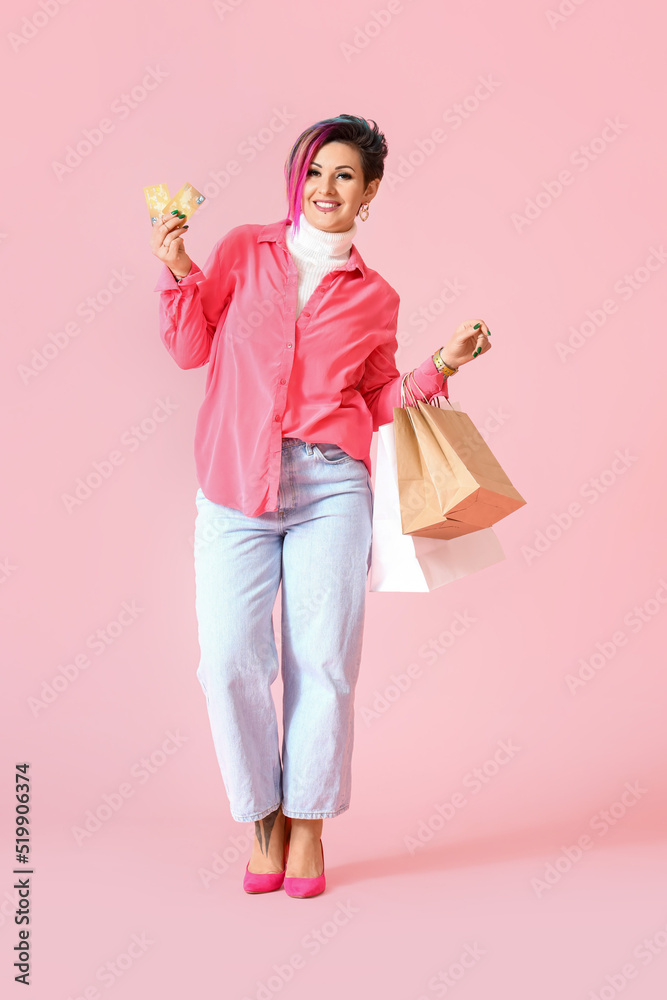 Beautiful woman with credit cards and shopping bags on pink background Beautiful woman with credit cards and shopping bags on pink background