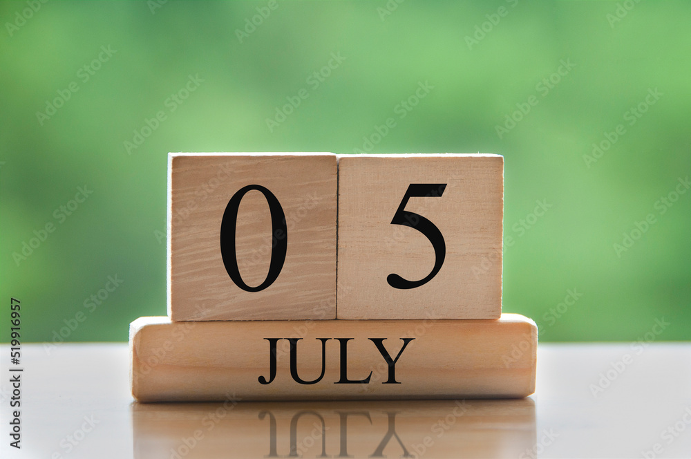 July 5 calendar date text on wooden blocks with blurred background park. Calendar concept July 5 calendar date text on wooden blocks with blurred background park. Calendar concept